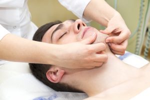 Zahnarzt Berlin - Junger Mann bei der Physiotherapie für Kiefergelenkserkrankungen - Zahnarztpraxis am Gendarmenmarkt